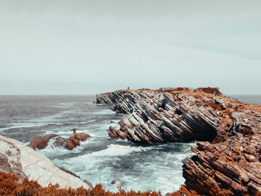 a rocky beach with waves crashing against it