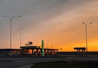 A serene petrol pump at sunset, bathed in warm light, reflecting a trusted community hub.