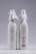Two elegant white bottles with ribbed texture and decorative cloth tied around the neck with bows. One bottle has embossed text and a cactus design on the front, while the other displays product details and a barcode.