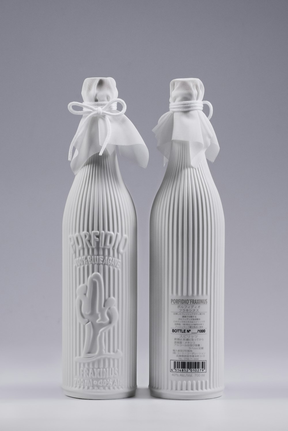 a couple of bottles with a white ribbon on top