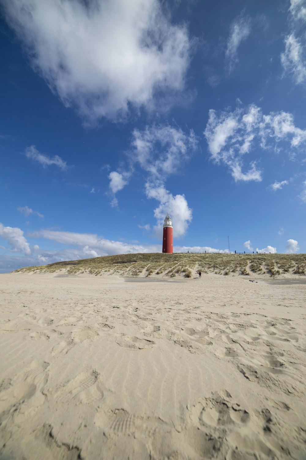 a sandy beach with a lighthouse