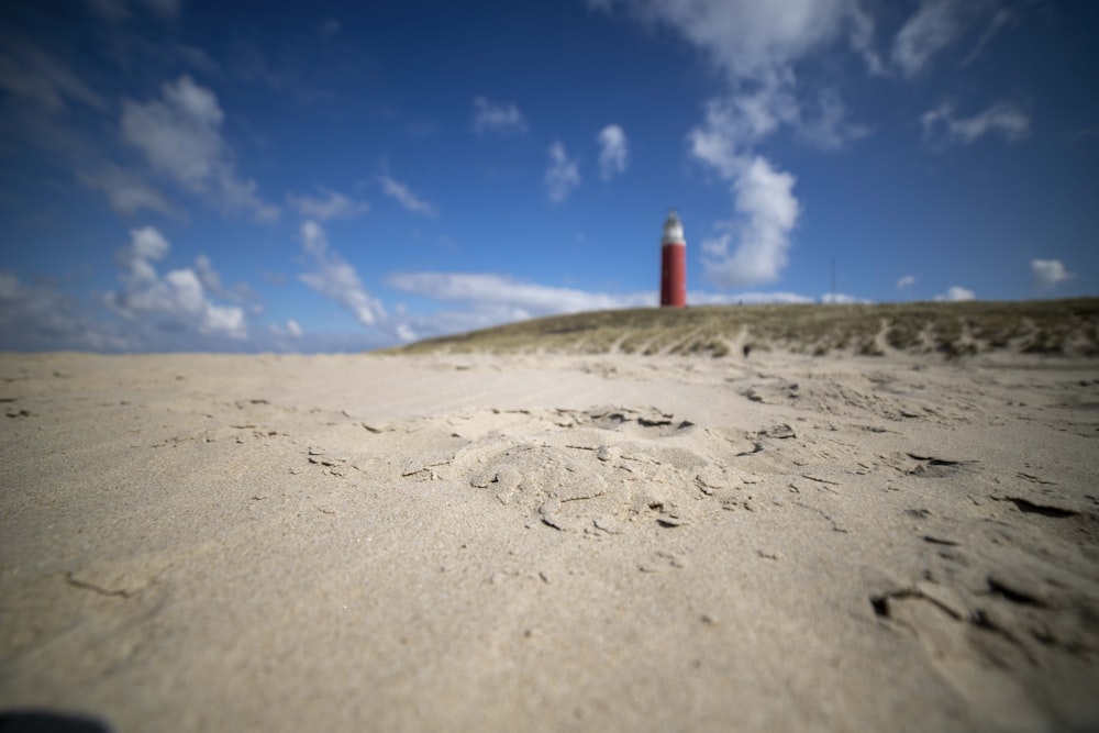 a sandy beach with a lighthouse