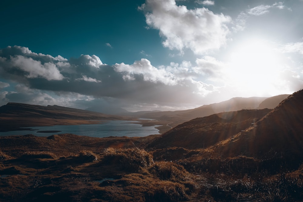 a landscape with hills and a body of water in the distance