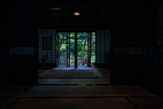 A tranquil treatment room softly lit with natural light and Japanese decor accents.