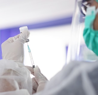 a person in a mask and gloves holding a syringe