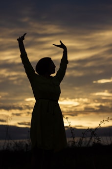 a statue of a person with the arms raised in the air