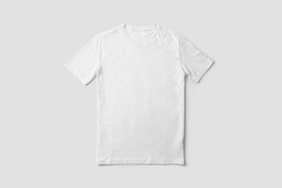 Folded boxy cotton tee on a pale studio backdrop — photo by mockupbee on Unsplash