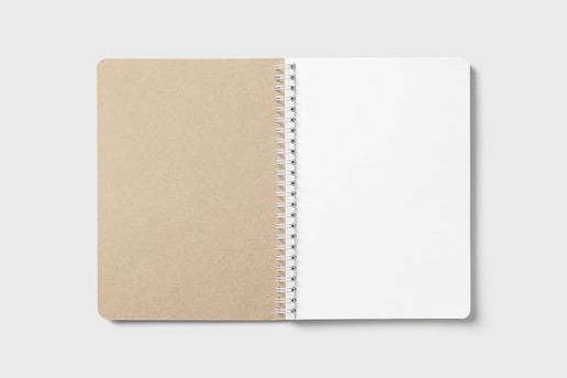 An open spiral-bound notebook on a plain background, with a brown cardboard cover on the left and blank white pages on the right.