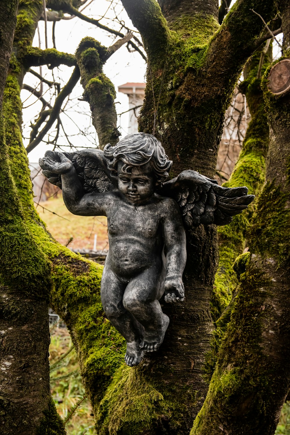 a statue of a person holding a baby in a tree