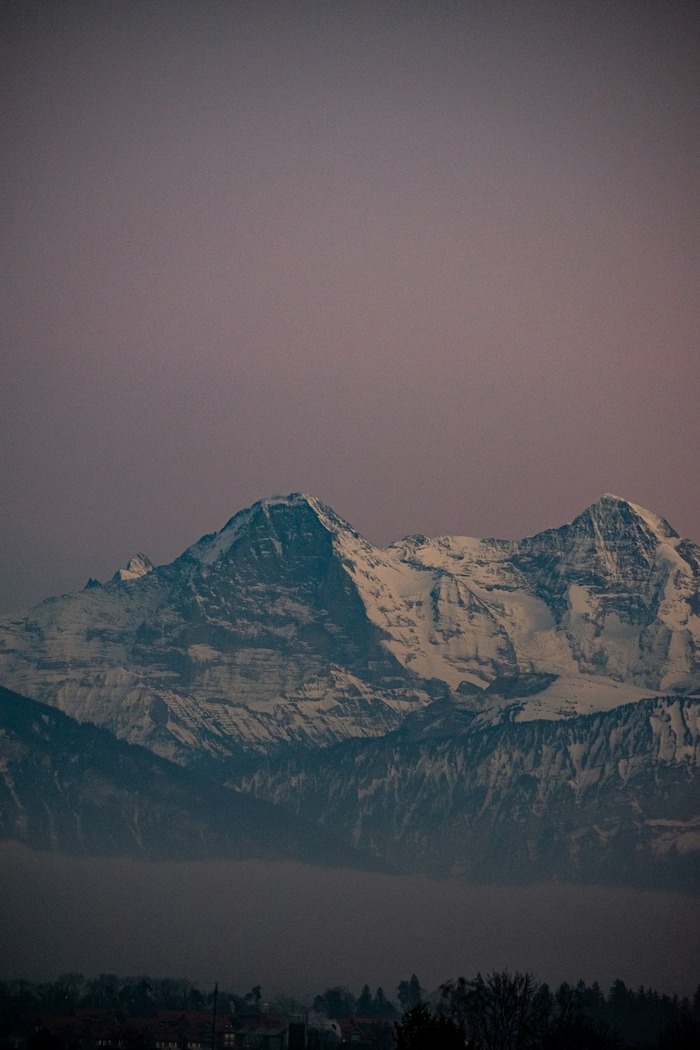 a snowy mountain with a purple sky