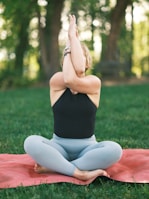 A peaceful yoga pose outdoors surrounded by lush greenery at sunrise.
