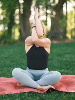 A serene yoga practitioner performing a Hatha pose outdoors surrounded by lush greenery.