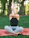 A serene portrait of a smiling man practicing gentle yoga outdoors surrounded by green foliage.