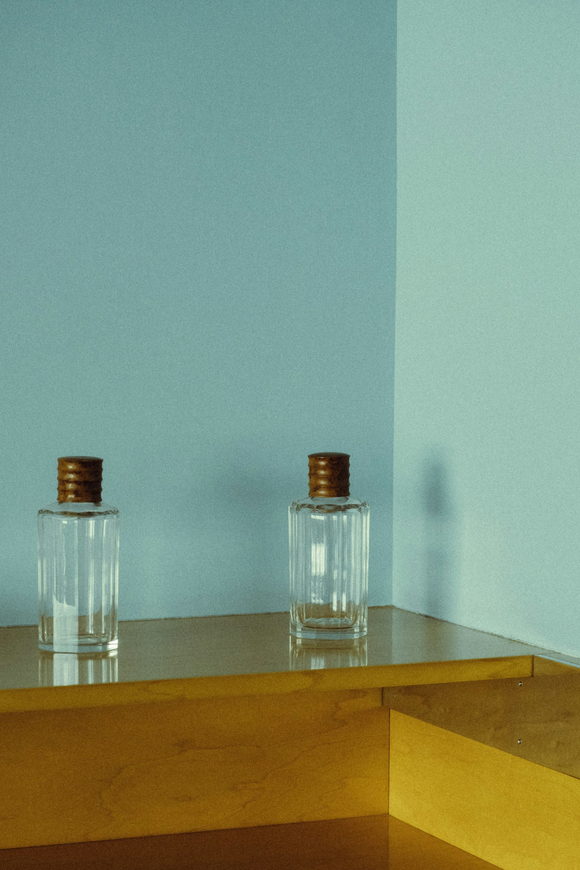 a couple glass bottles on a shelf