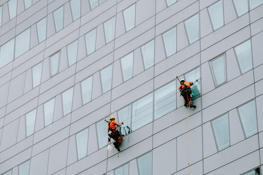 a few men climbing a building