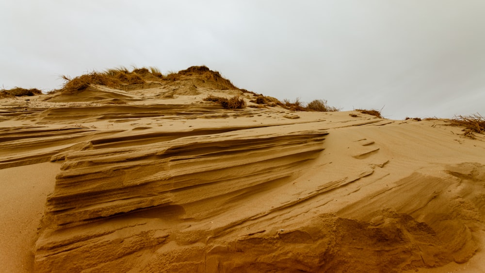 a sandy area with hills in the background