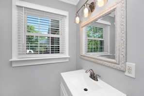 Bright bathroom with large mirrors and custom cabinetry