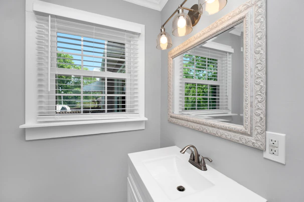 Bathroom with sleek fixtures and a large mirror reflecting natural light