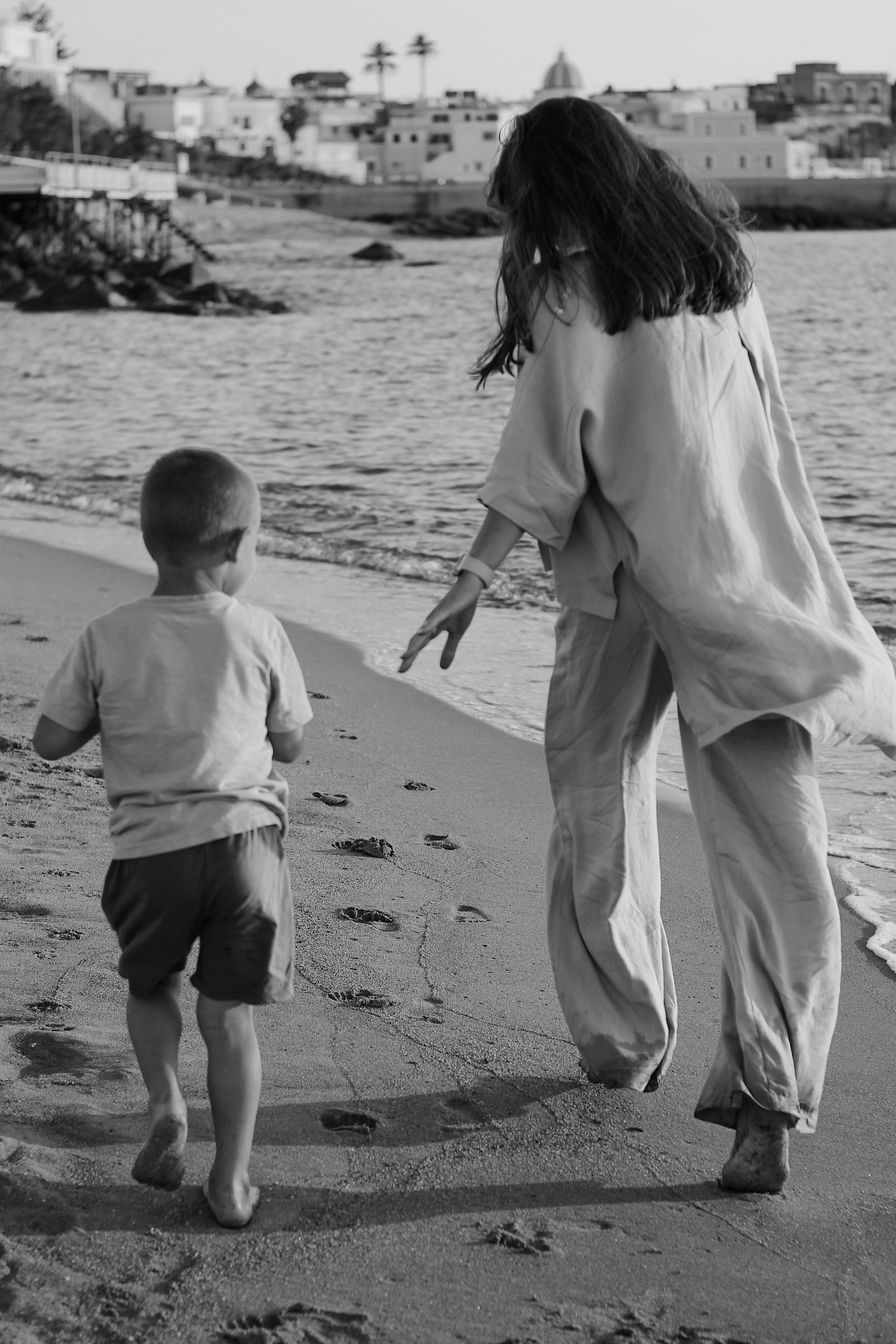 seseorang dan seorang anak berjalan di pantai