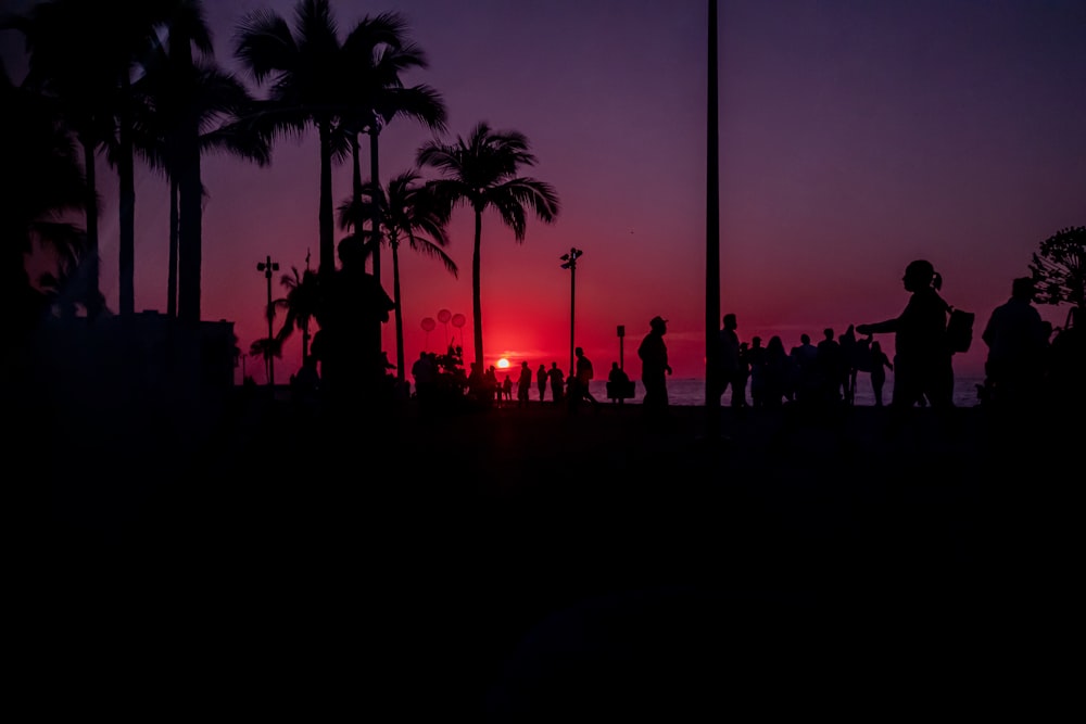 a group of people standing in front of a sunset