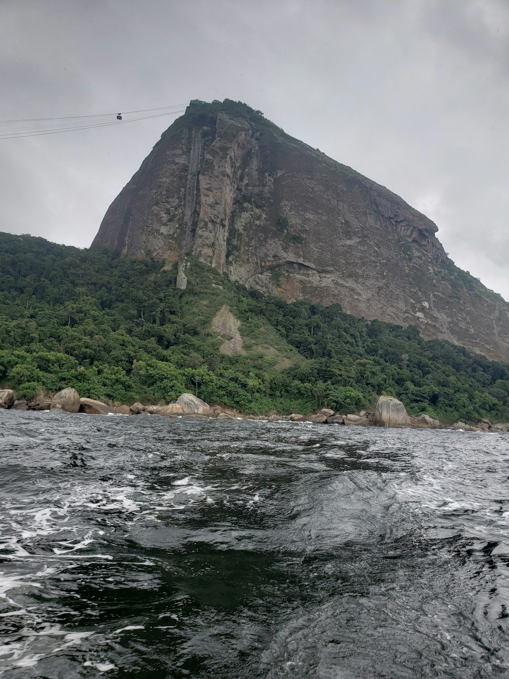 a rocky cliff next to a body of water