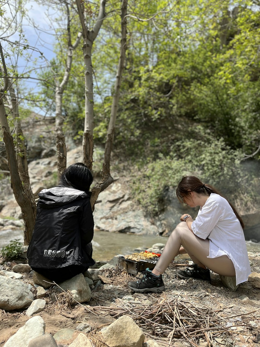 a person sitting on a rock next to a backpack