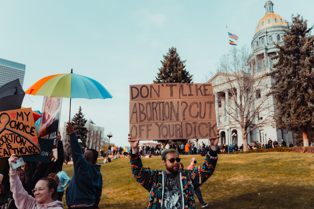 a group of people holding signs and a sign