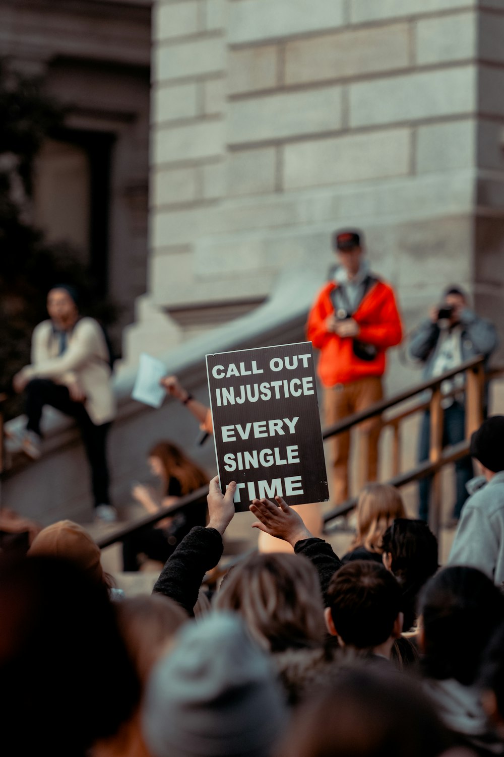 a person holding a sign in front of a crowd