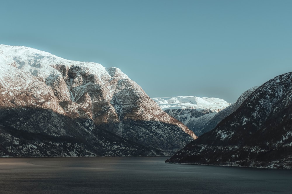 a body of water with mountains in the back