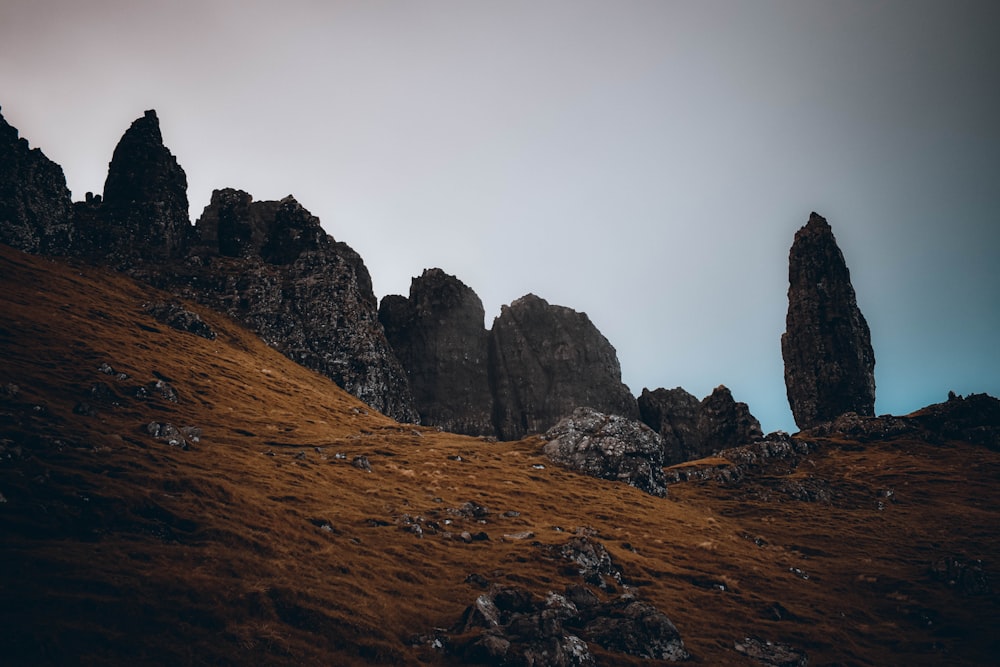 a rocky mountain with a foggy sky