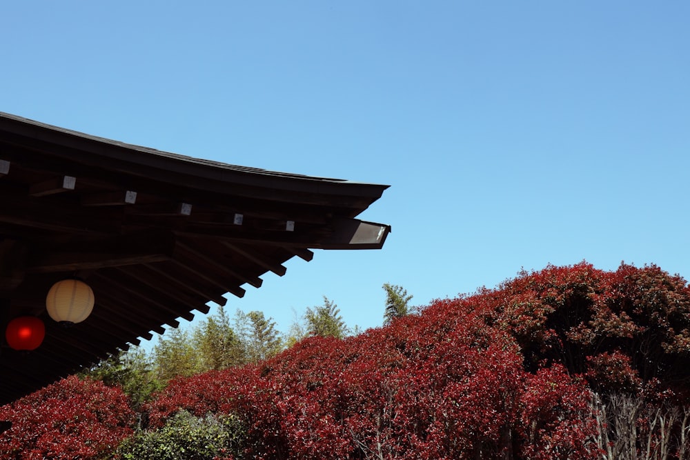 a building with a red roof and trees in the front