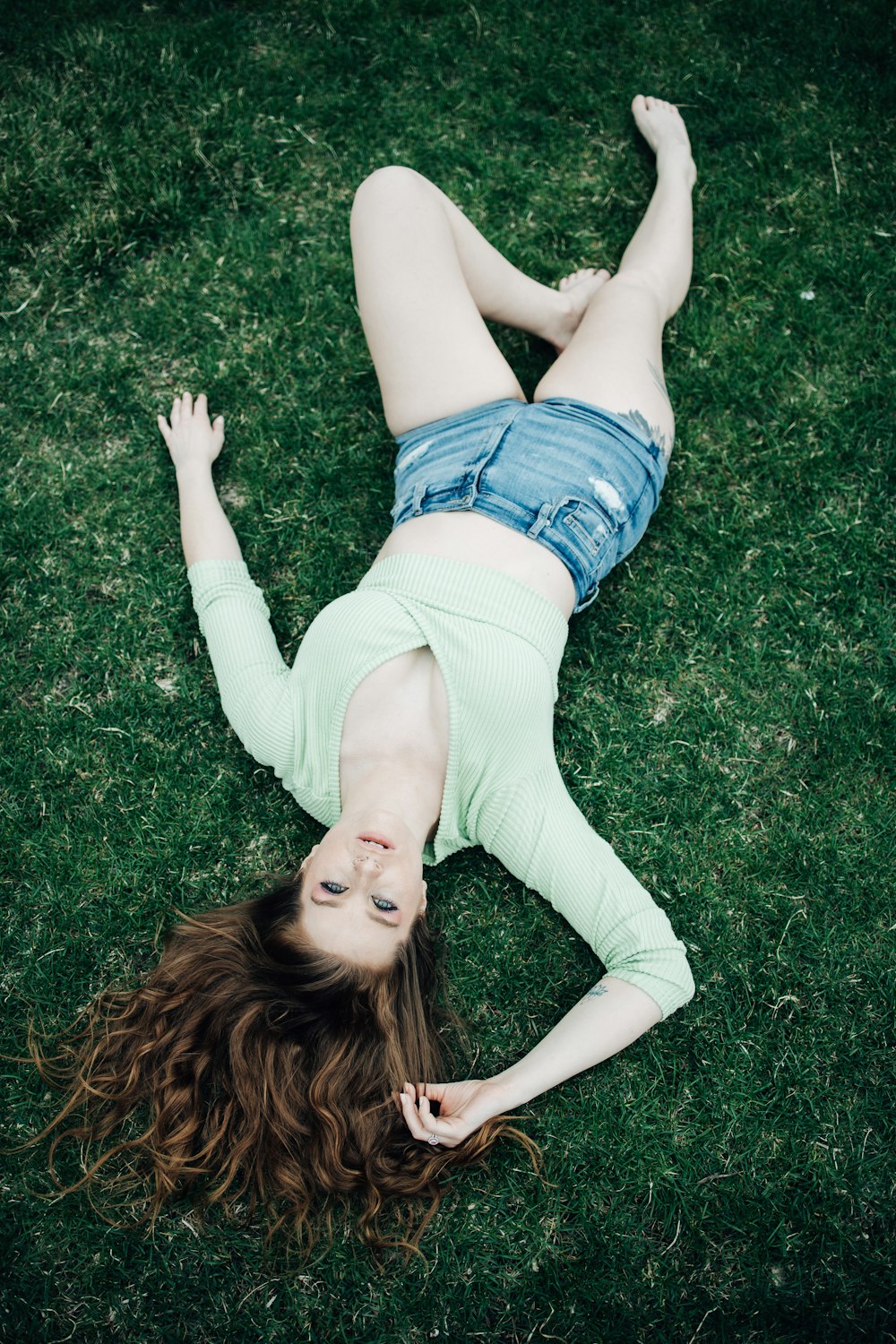 a woman lying on her back in the grass