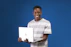 A smiling technician in a navy uniform fixing a laptop at a customer's cozy living room.