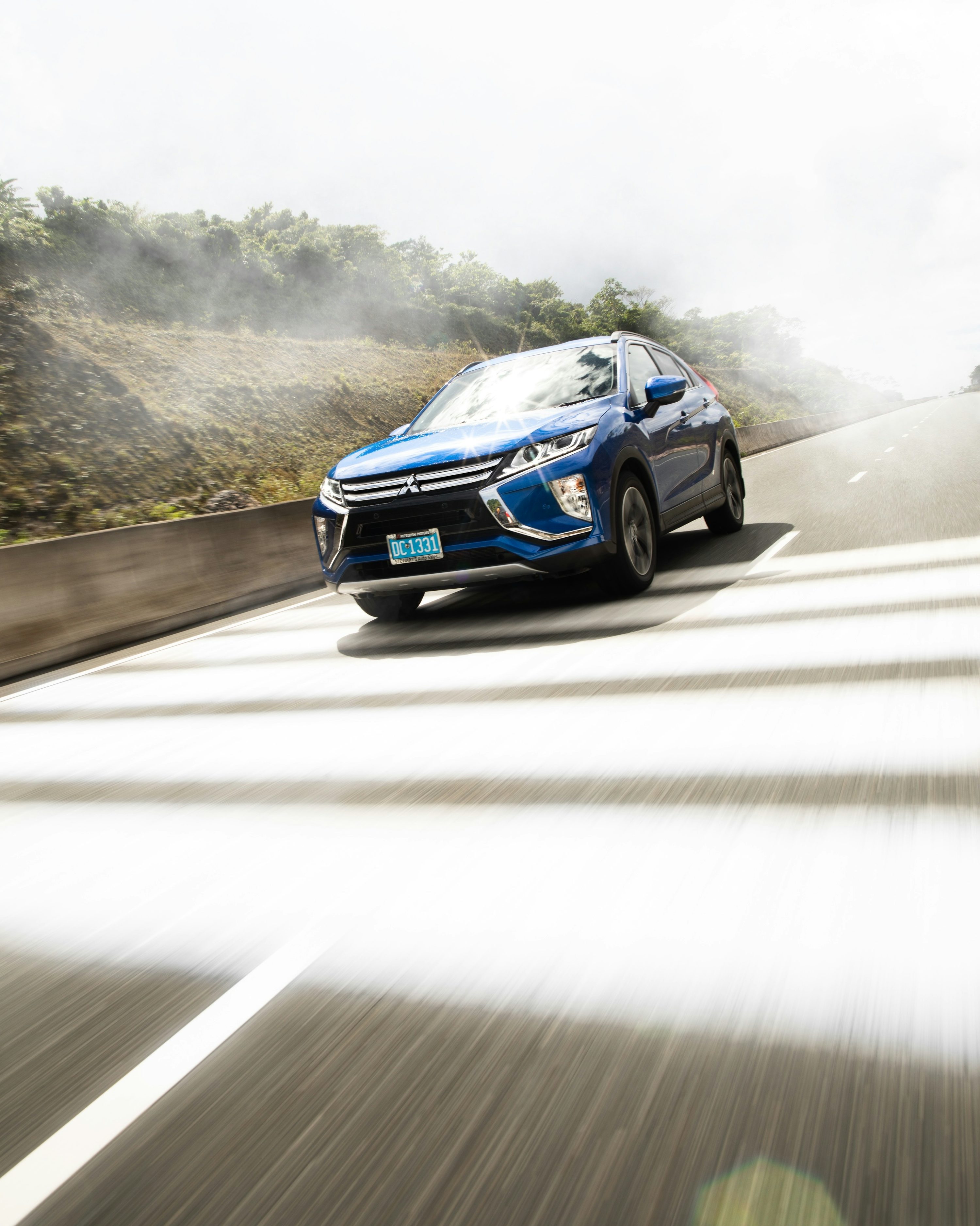 a blue car driving on a road