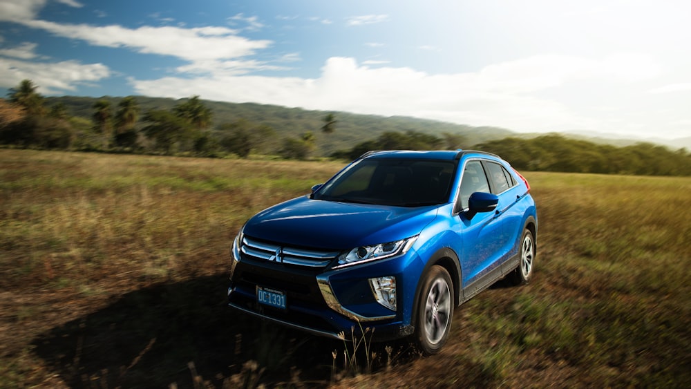 a blue car parked on a dirt road