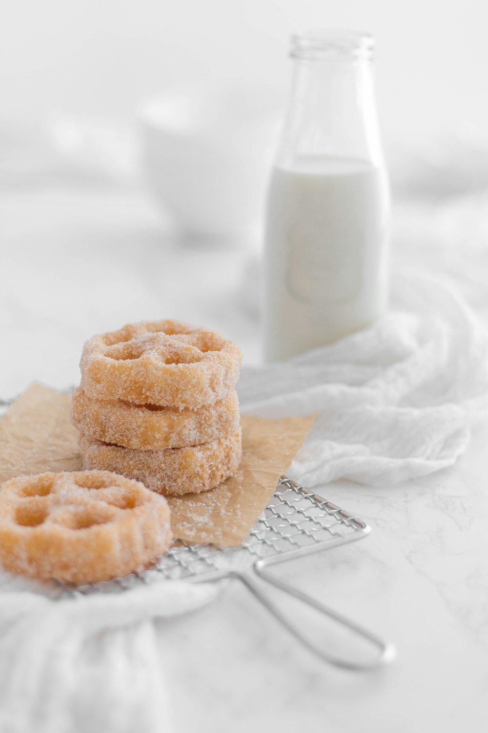 a few muffins on a plate next to a glass of milk