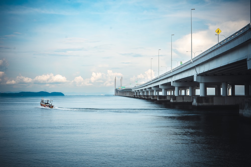 a boat sailing under a bridge