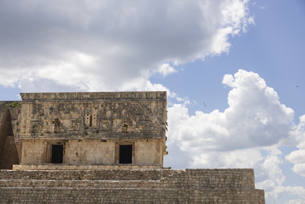 a stone building with a cloudy sky