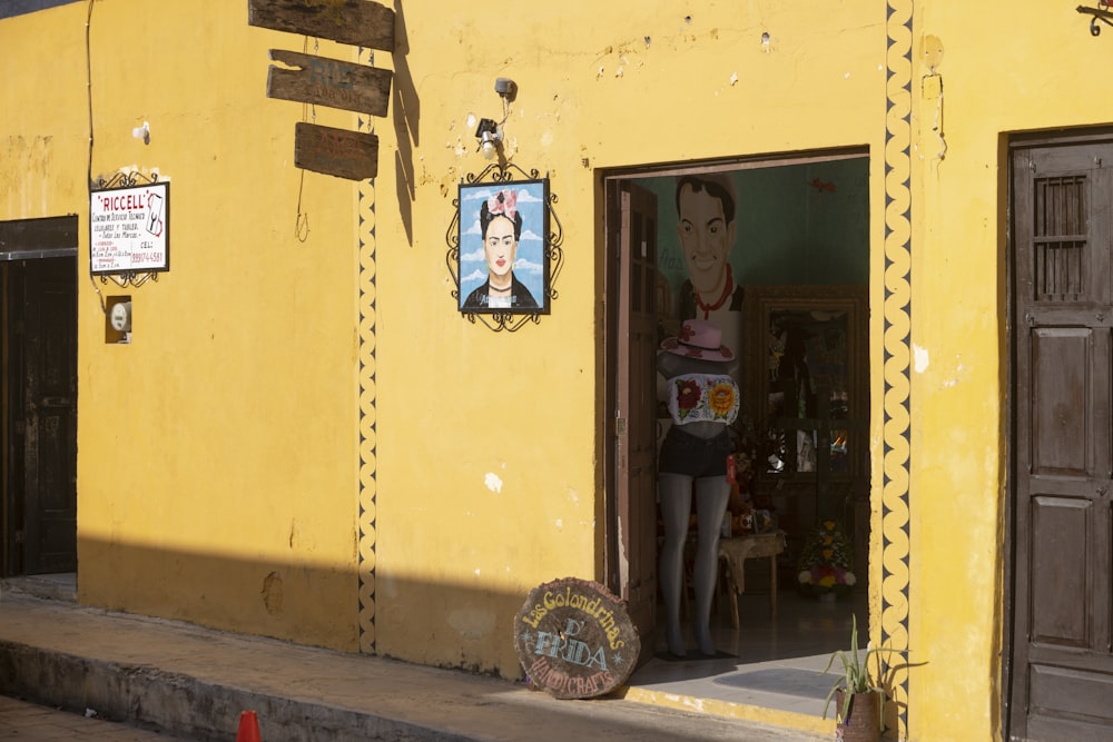 a yellow building with a mural on the side