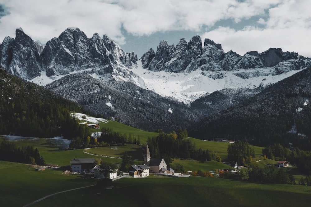 a valley between mountains with houses and trees