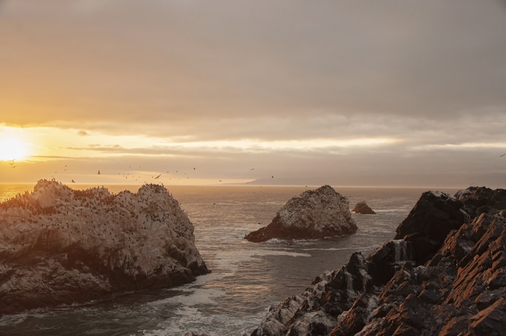 a rocky beach with a sunset