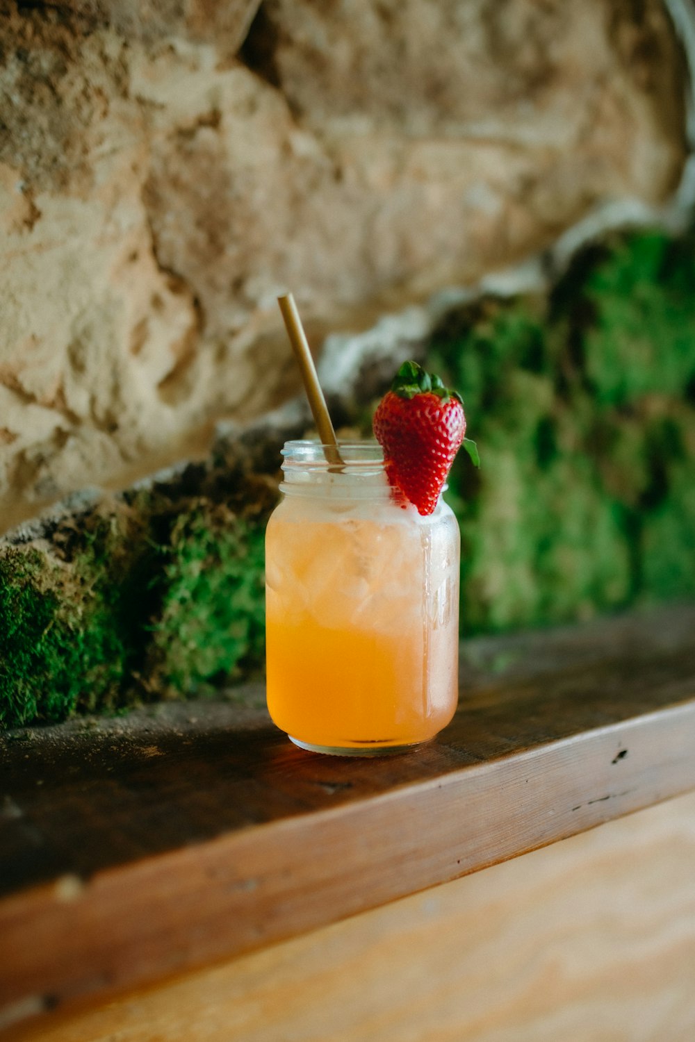 a glass with a straw and a strawberry in it