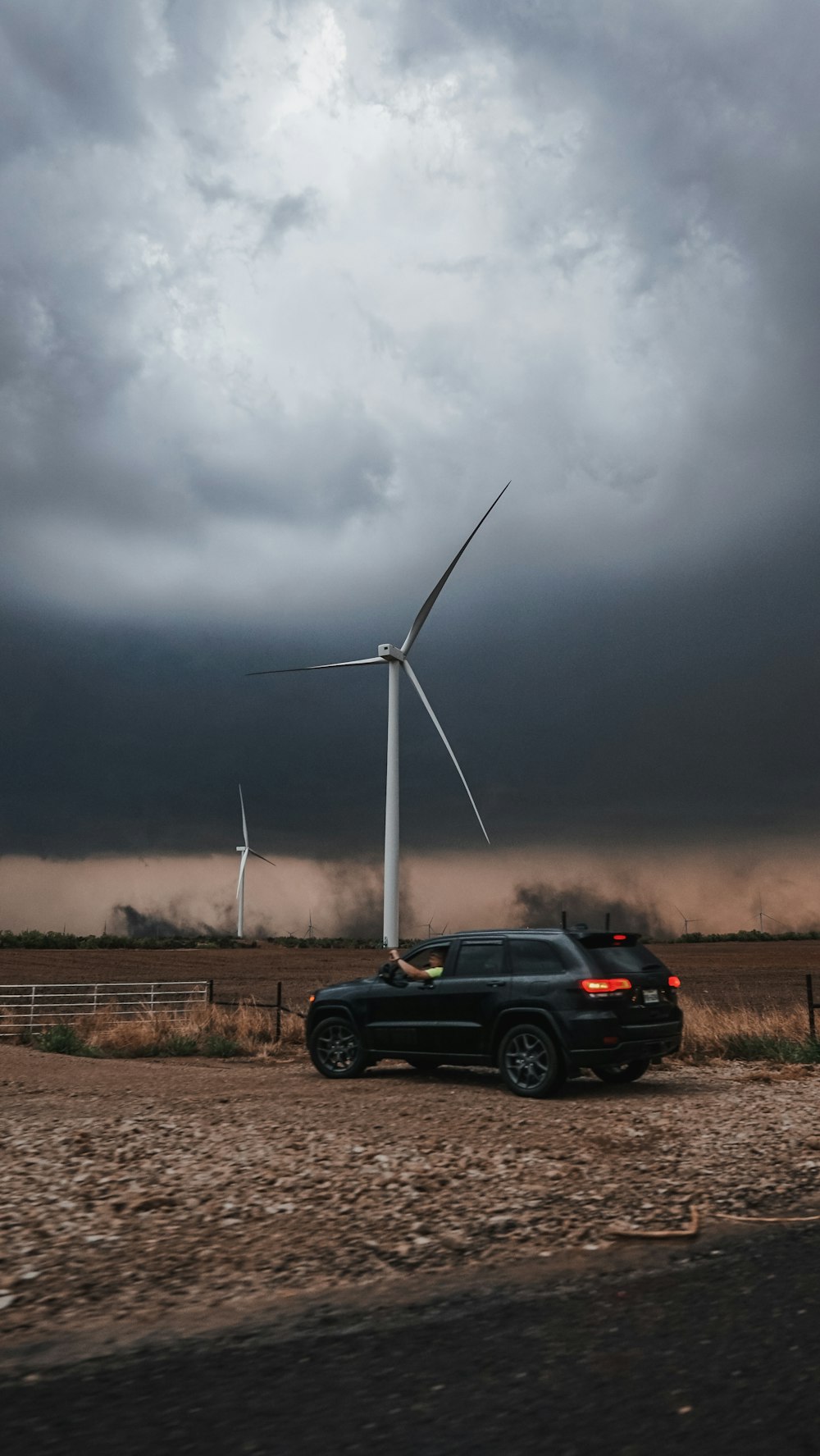 a car parked in front of a windmill