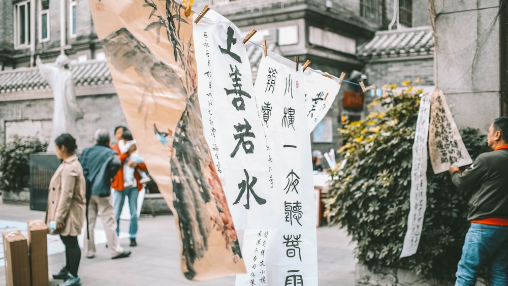 a group of people walking on a sidewalk with a sign