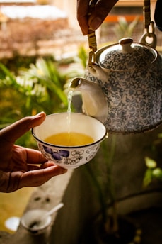 a hand holding a tea cup