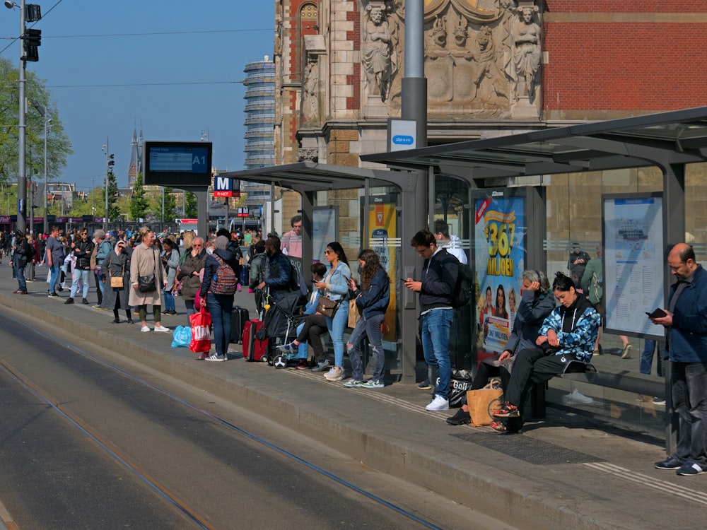 a group of people waiting at a bus stop