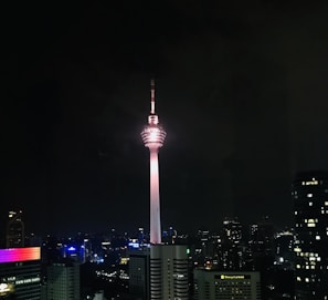 A vibrant city skyline at dusk with glowing telecom towers transmitting signals.