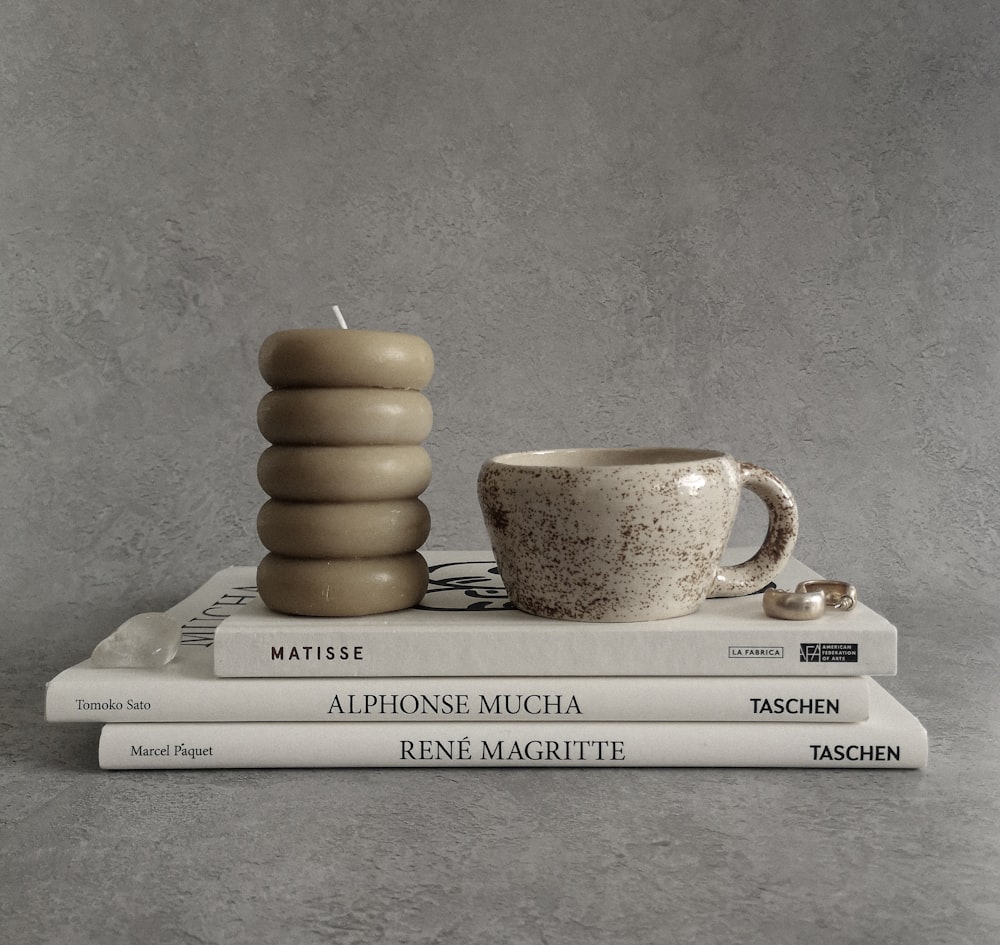 a stack of books and a cup