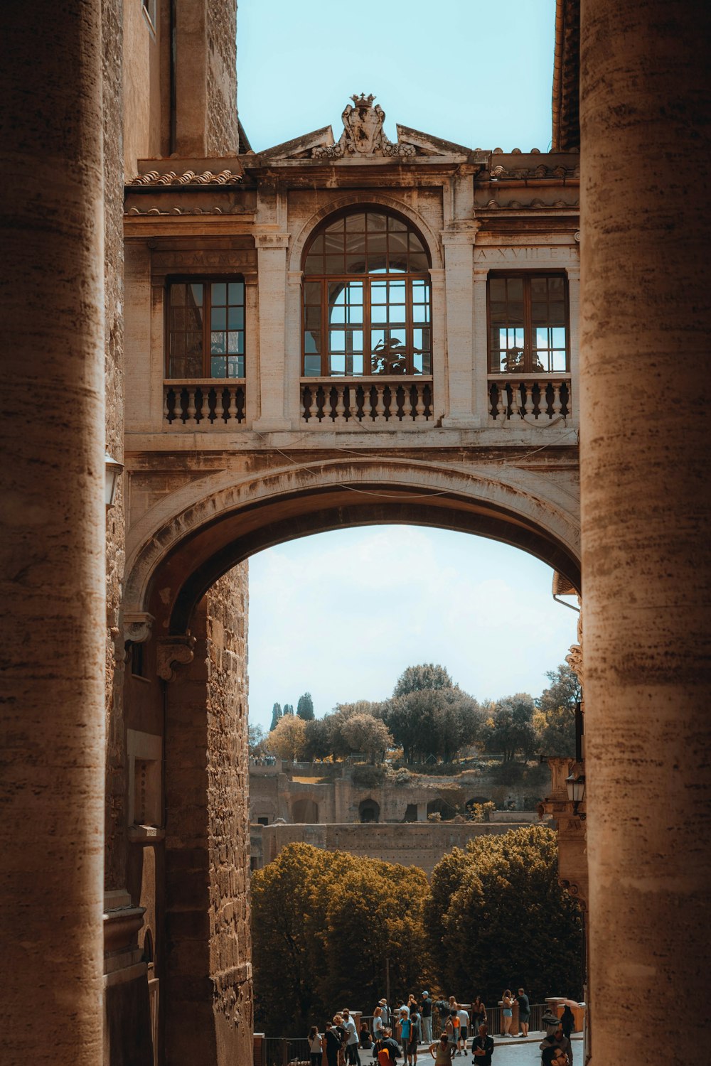 a large stone archway with a group of people walking underneath