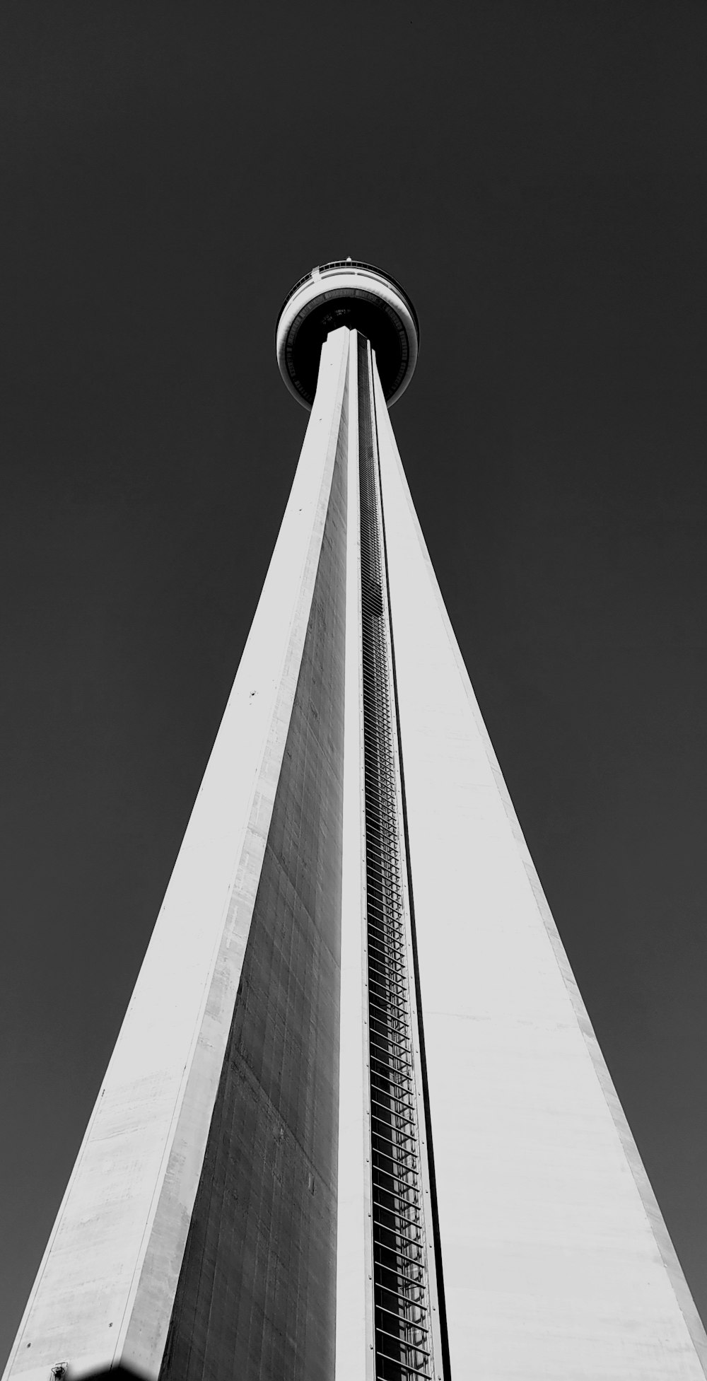 a tall tower with a circular top with CN Tower in the background